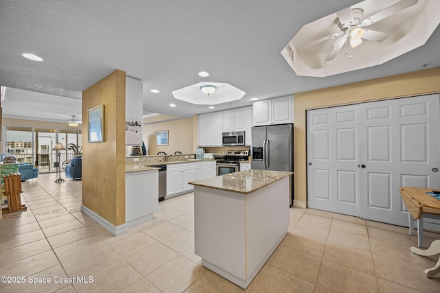 kitchen with white cabinets, a textured ceiling, ceiling fan, kitchen peninsula, and appliances with stainless steel finishes