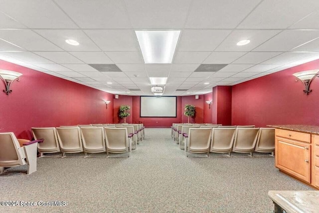 home theater room with a paneled ceiling and carpet flooring