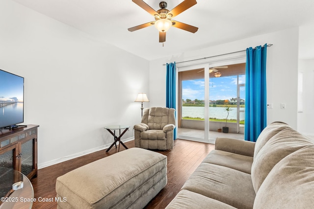 living room featuring a water view, ceiling fan, and dark wood-type flooring