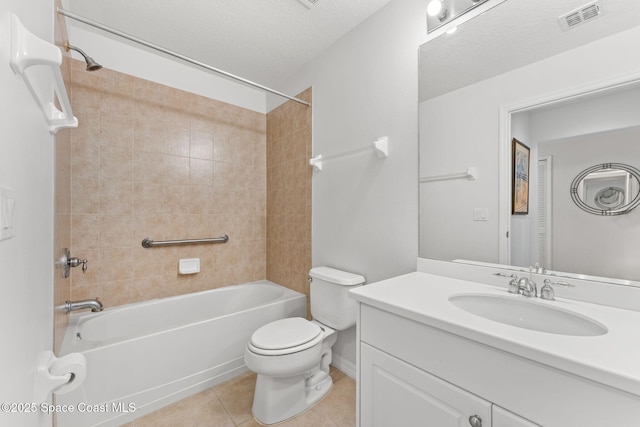 full bathroom featuring vanity, a textured ceiling, tiled shower / bath, tile patterned floors, and toilet