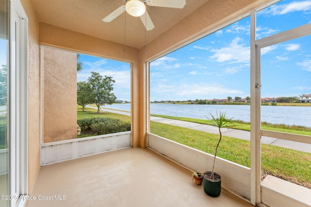 unfurnished sunroom featuring a water view and ceiling fan