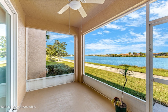 unfurnished sunroom with a water view and ceiling fan