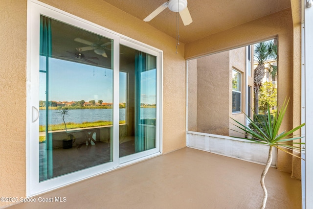 exterior space with a patio area, ceiling fan, and a water view