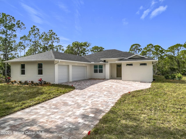 single story home featuring a front lawn and a garage