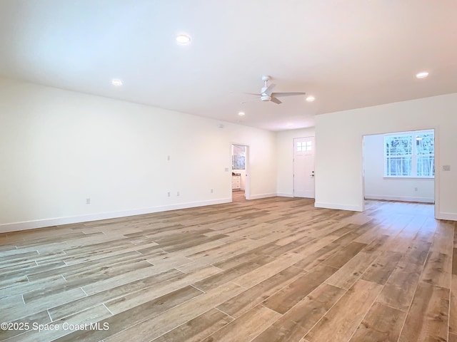 unfurnished living room featuring ceiling fan and light hardwood / wood-style flooring