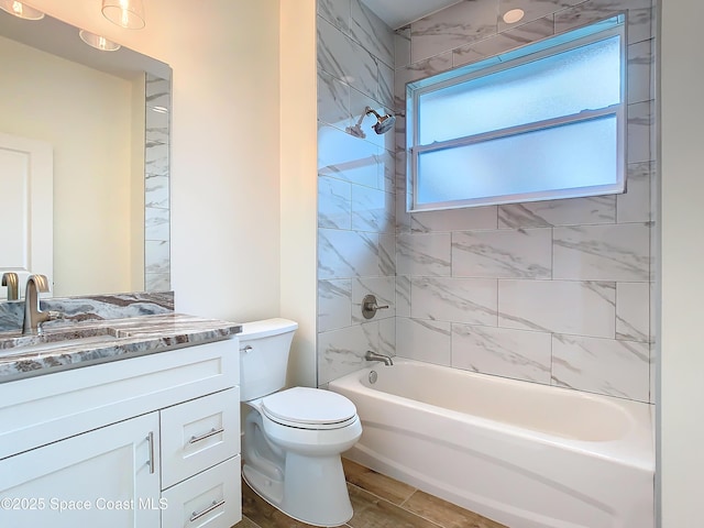 full bathroom featuring toilet, tiled shower / bath, and vanity