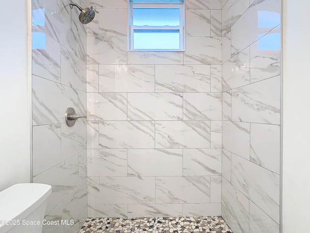 bathroom featuring toilet and tiled shower