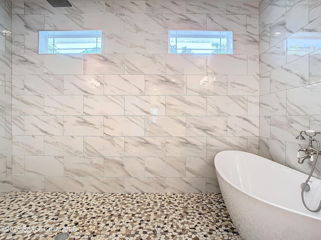 bathroom featuring independent shower and bath and tile walls