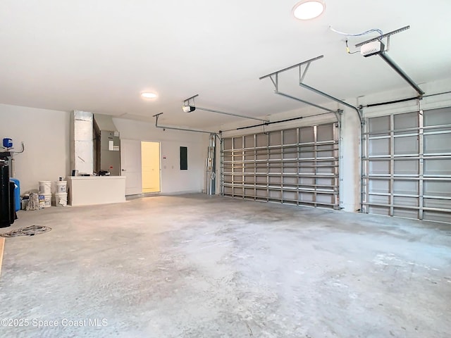 garage featuring a garage door opener, electric panel, and heating unit