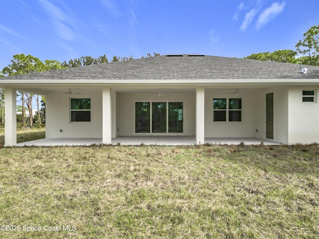 rear view of property featuring ceiling fan, a yard, and a patio