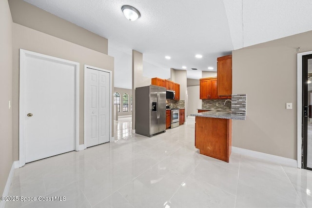 kitchen featuring kitchen peninsula, stainless steel appliances, decorative backsplash, light tile patterned flooring, and sink