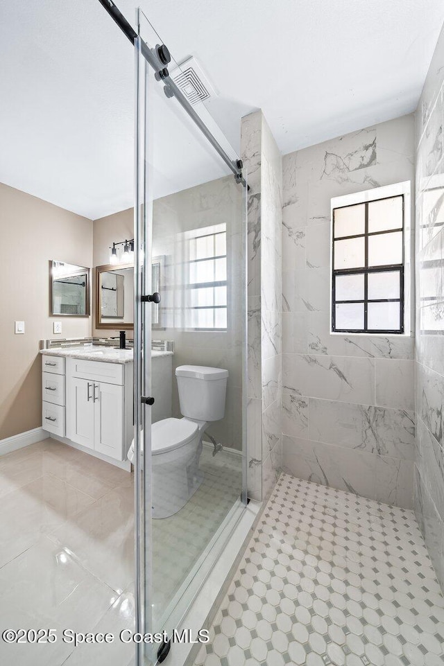 bathroom featuring toilet, vanity, and a tile shower