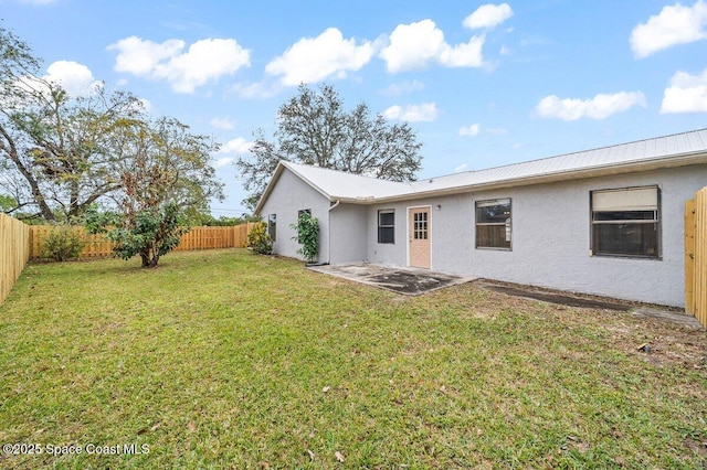 rear view of house featuring a patio area and a lawn