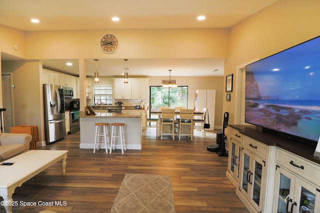 living room featuring a notable chandelier, sink, and dark hardwood / wood-style floors