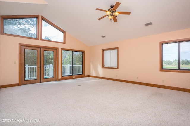 carpeted empty room with ceiling fan, french doors, and vaulted ceiling