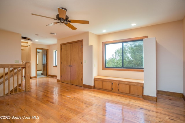 unfurnished living room featuring light wood-type flooring and ceiling fan