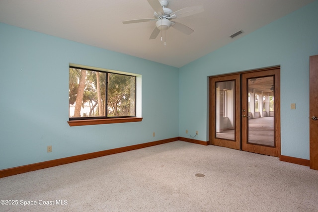 carpeted spare room with ceiling fan, french doors, and lofted ceiling