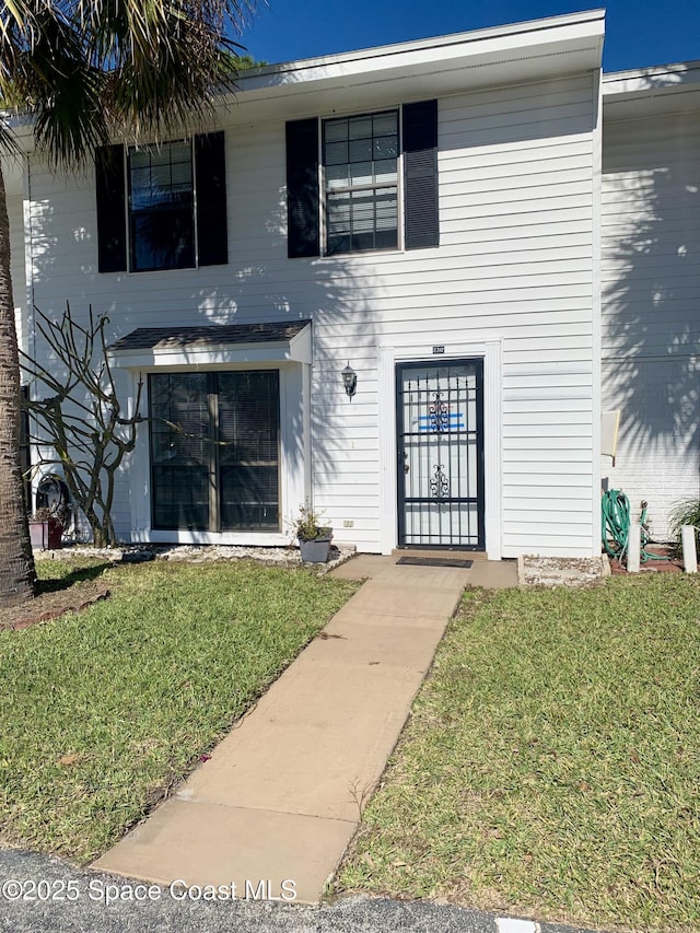 entrance to property featuring a lawn