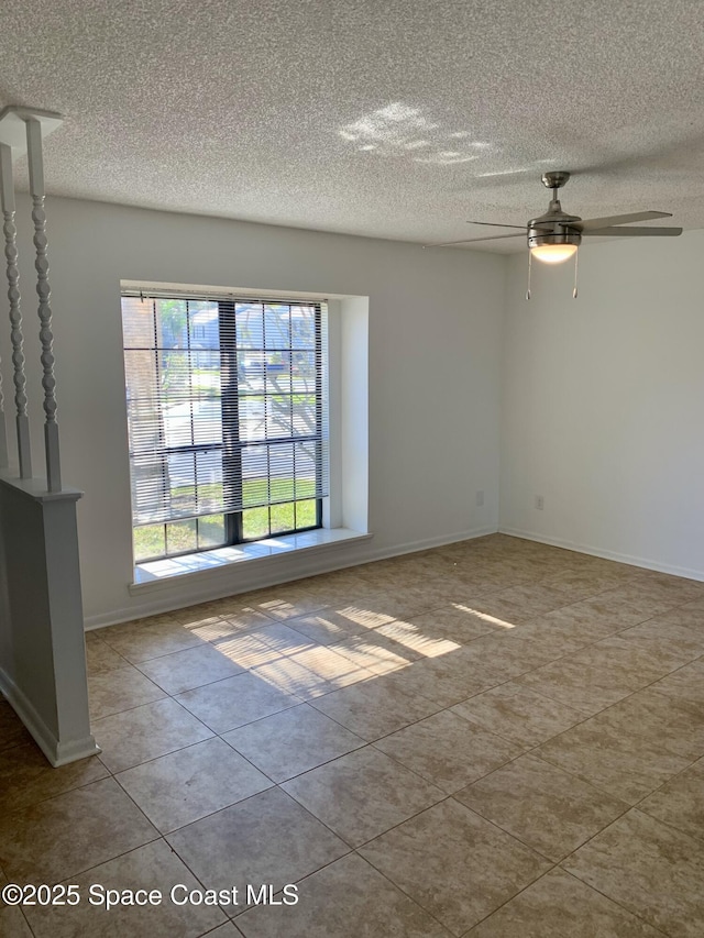 tiled empty room featuring ceiling fan