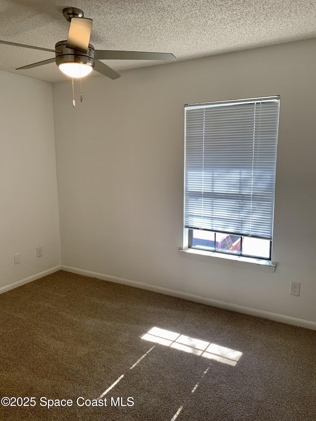 carpeted spare room with ceiling fan and a textured ceiling