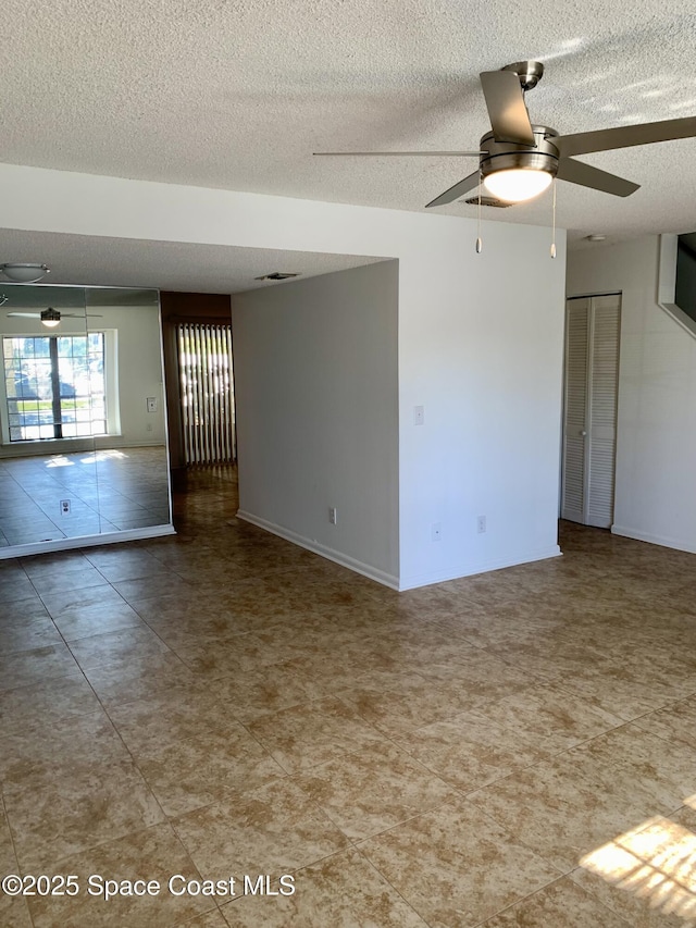 empty room featuring ceiling fan and a textured ceiling