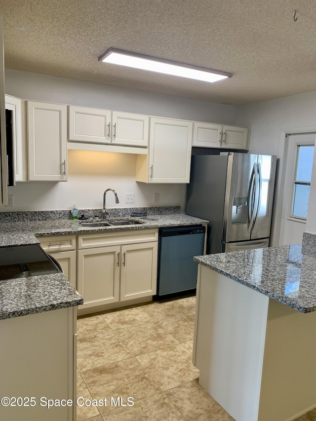 kitchen with a textured ceiling, white cabinets, sink, and stainless steel appliances