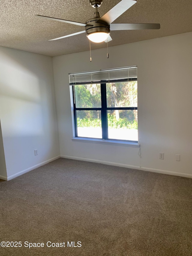 carpeted empty room featuring ceiling fan and a textured ceiling