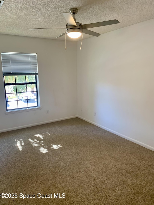 carpeted spare room featuring ceiling fan and a textured ceiling