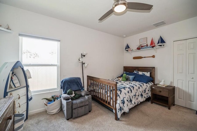 bedroom featuring ceiling fan, a closet, and light carpet