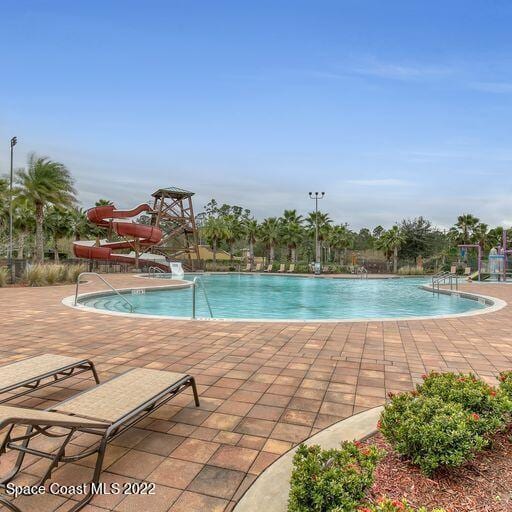 view of pool with a patio area and a water slide