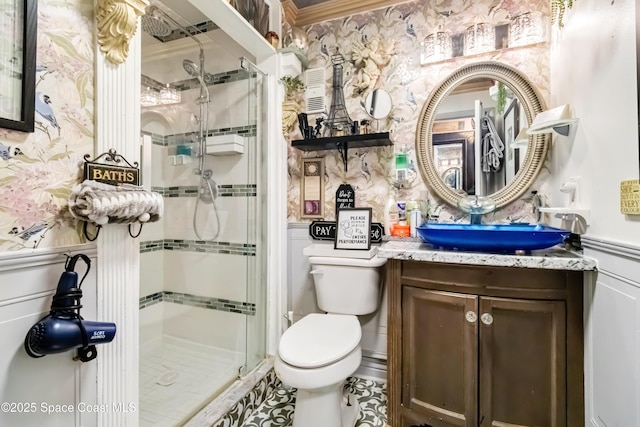 bathroom with toilet, vanity, and a shower with shower door