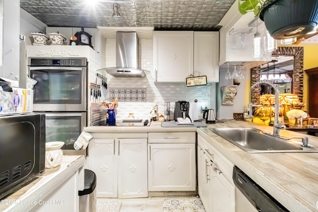 kitchen featuring white cabinets, decorative backsplash, range hood, and appliances with stainless steel finishes