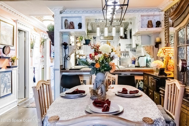 dining space featuring wood-type flooring, an inviting chandelier, and crown molding