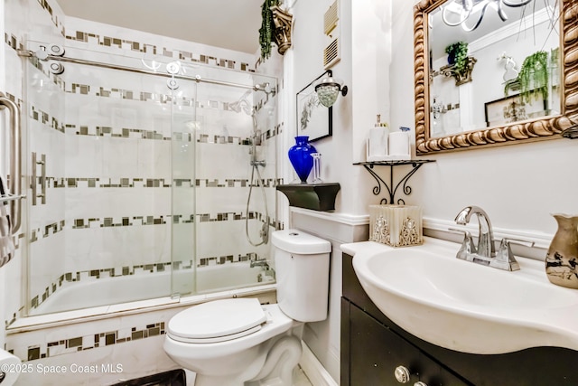 full bathroom featuring toilet, combined bath / shower with glass door, and vanity