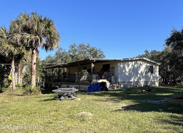 rear view of house with a lawn and a wooden deck