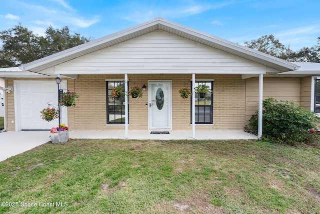 ranch-style home featuring a front lawn, a porch, and a garage