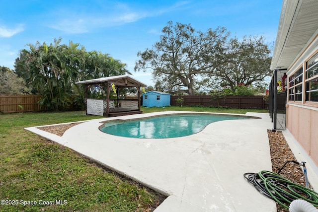 view of swimming pool with a gazebo, a storage shed, and a lawn