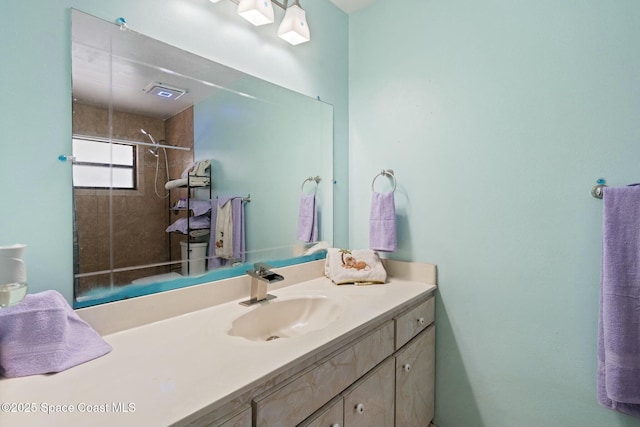 bathroom with vanity and tiled shower