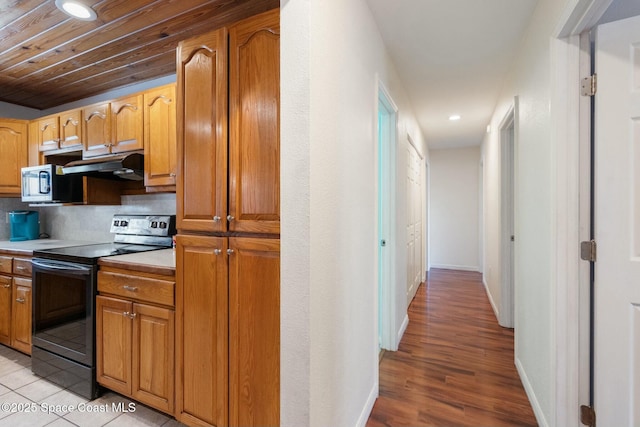 kitchen featuring decorative backsplash, black range with electric cooktop, light hardwood / wood-style floors, and wooden ceiling