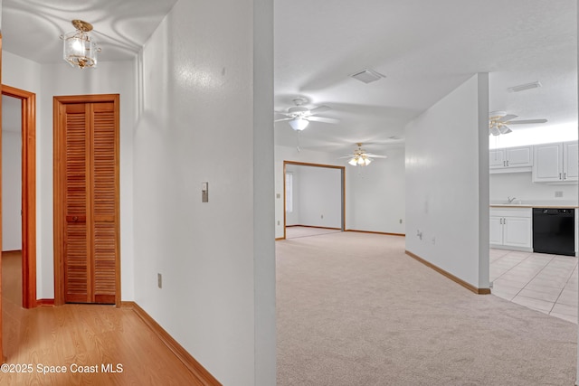 hallway with sink and light carpet