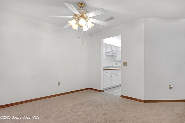 spare room featuring ceiling fan, light colored carpet, and sink