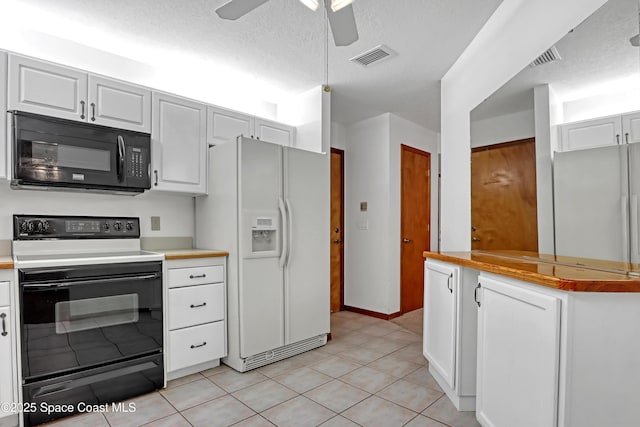 kitchen with light tile patterned floors, a textured ceiling, white cabinets, and black appliances