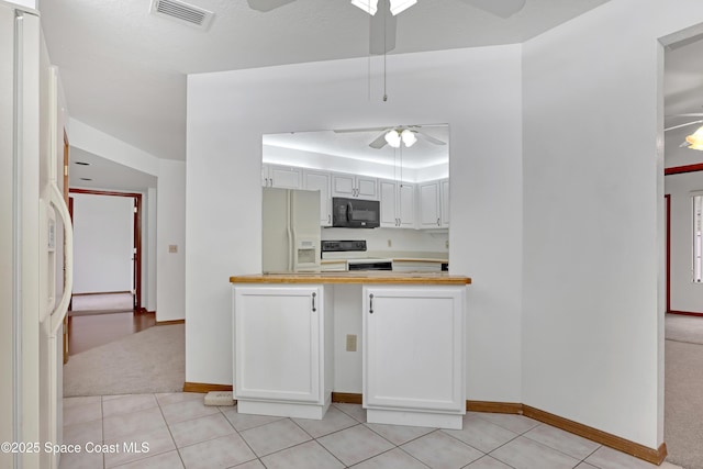 kitchen featuring white cabinets, range with electric stovetop, white refrigerator with ice dispenser, and light colored carpet