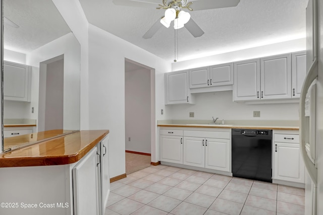 kitchen featuring light tile patterned floors, white cabinets, and black dishwasher