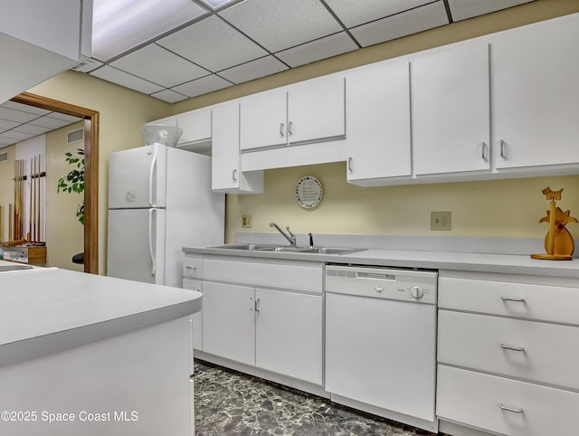 kitchen featuring sink, white appliances, white cabinets, and a paneled ceiling