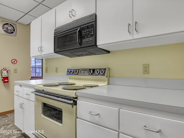 kitchen featuring a paneled ceiling, white electric range oven, and white cabinetry