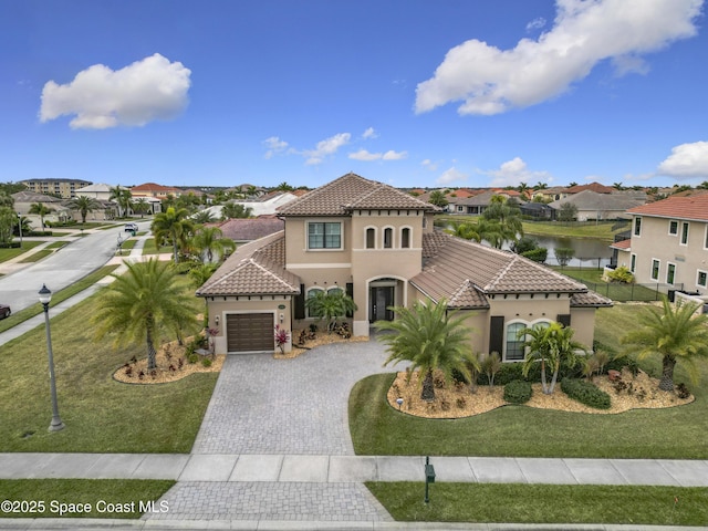 mediterranean / spanish-style house featuring a garage, a water view, and a front yard