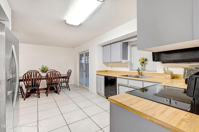 kitchen with sink, a textured ceiling, stainless steel fridge with ice dispenser, and wooden counters