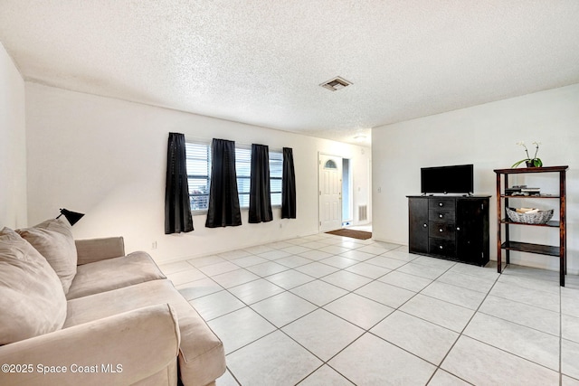 living room with a textured ceiling and light tile patterned floors