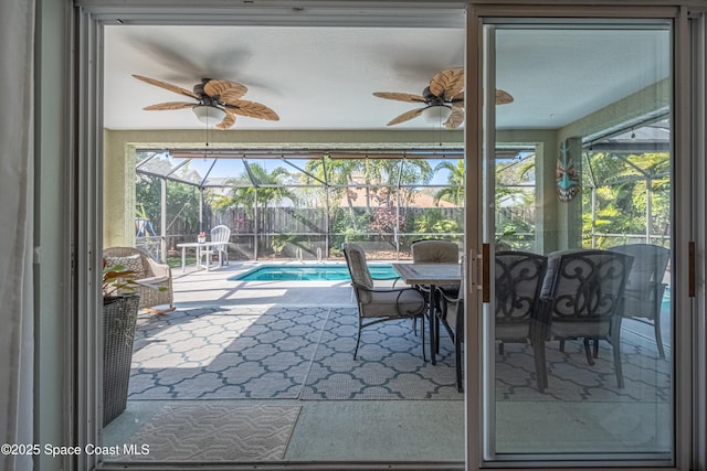 sunroom / solarium with ceiling fan and a pool